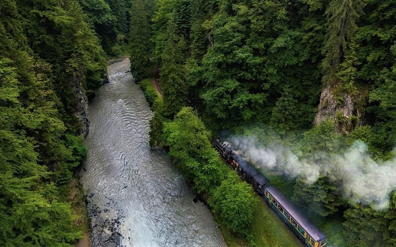 عبور قطار از کنار رودخانه‌ای در رومانی، منبع عکس: اینستاگرام alexrobciuc@، عکاس: Alex Robciuc