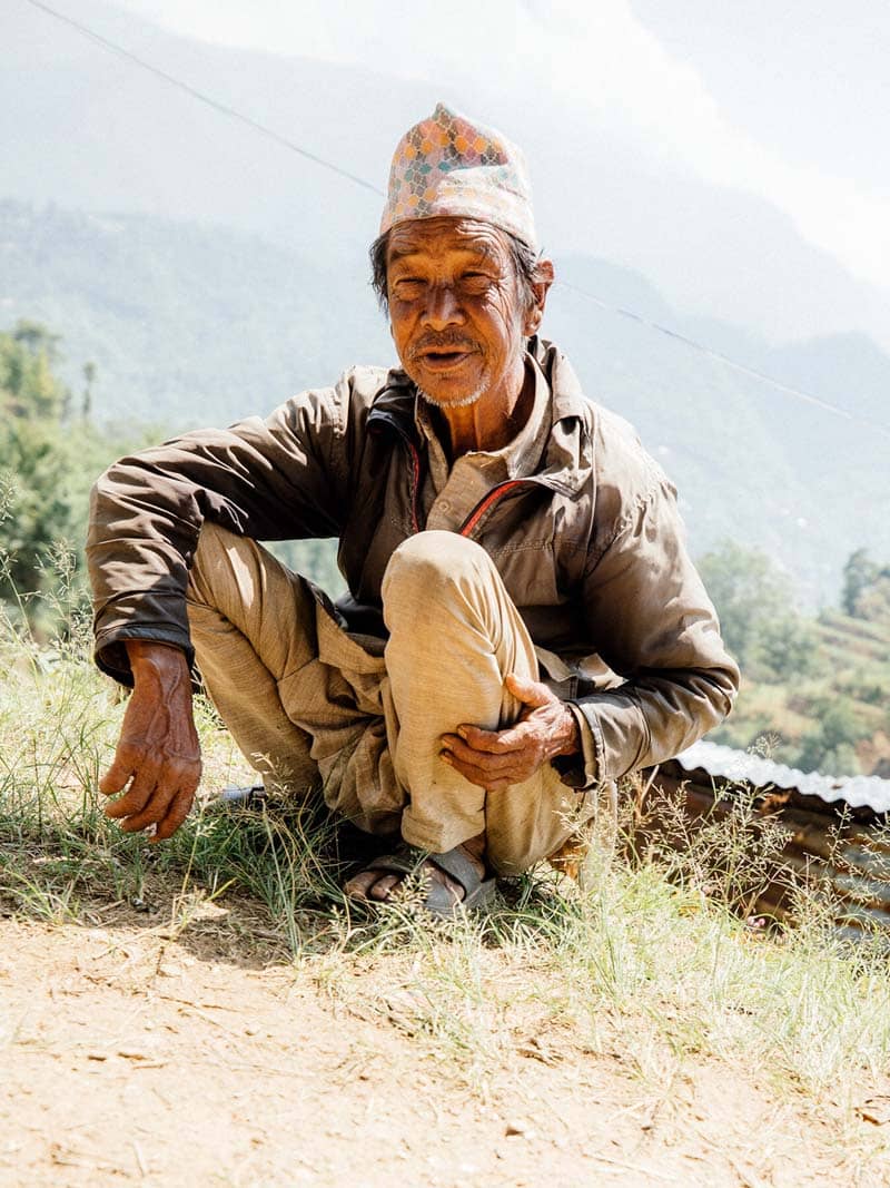 مرد اهل نپال نشسته در میان دشت