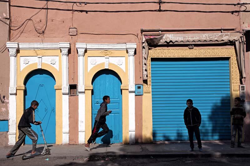 بازی و دویدن نوجوانان مراکشی مقابل ساختمان‌های قدیمی