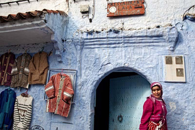 زن جوان مراکشی مقابل یک لباس فروشی قدیمی
